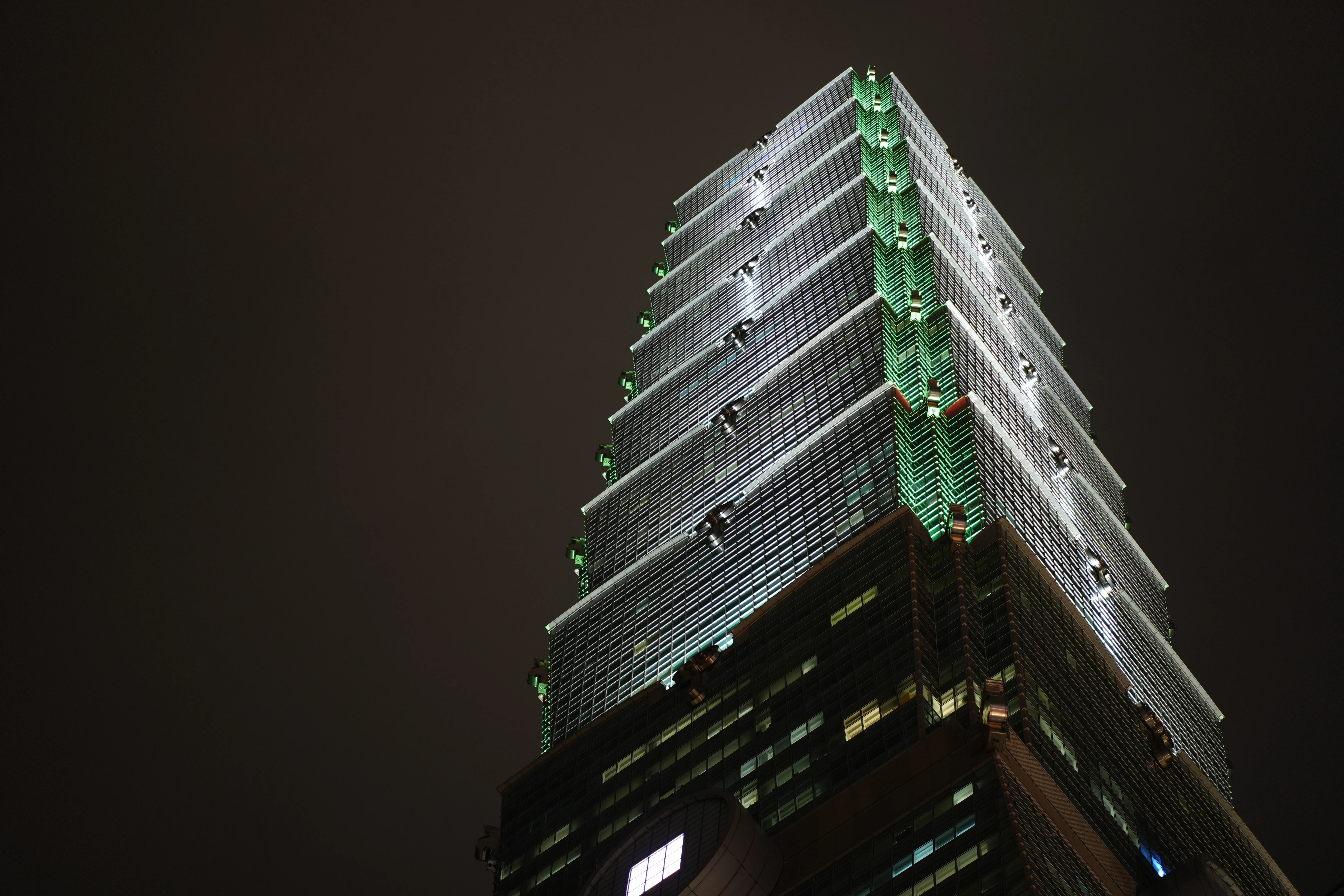 An illuminated stepped tower rises diagonally into the dark sky.